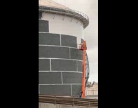 Man on boom lift painting buildings wall 