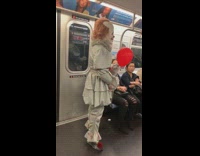Pennywise the Clown with red balloon rides subway train