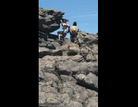 Girl shirt hat taught hold rock mountain