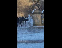 Guy in silver wing outfit spreads arms 
