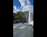 Man ride bike around water fountain carry tire