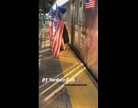 Man in Yankees gear blue afro and American flags gets on train