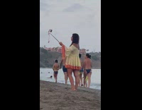 Woman off shoulder bikini dress selfie stick beach