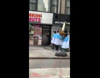 Guy drives by men carrying religious statue 