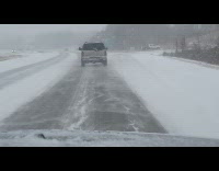 Car drives make snow waves on road