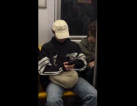 Person on subway wearing cap with funny print