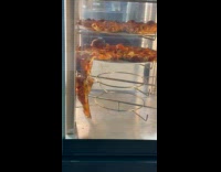 Pizza hangs on another pizza on Lazy Susan