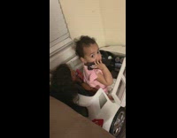 Little baby girl gets caught talking to somebody on a cellphone while sitting on toy car