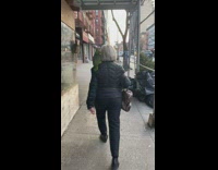 Woman walk street green bird on shoulder