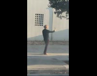Woman black top pigtail sidewalk selfie sunlight