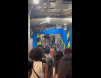 People climb up stairs where flood rushes