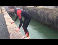 Black red wetsuit guy backflips green water