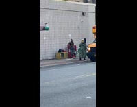 Woman dances in sports bra next to school bus 