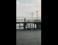 Man fishing on pier during  heavy rain