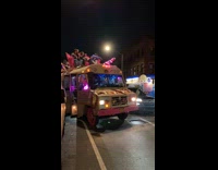 People rides at top of the mini bus at night in NY 