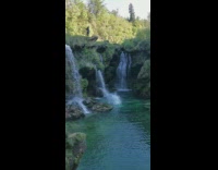 Guy backflips mossy rocks waterfalls green water 