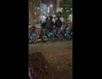 Two boys ride on the bicycle park on the street in NY 
