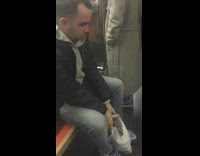 man in leather jacket and hoodie flosses on subway
