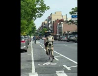 Guy rides bike with two skeletons on it