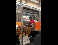 Man wearing kings robe and crown on subway