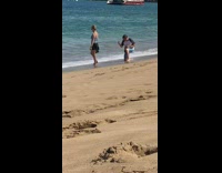 Woman blue top black skirt stand beach