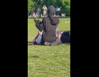 Man sitting on grass holding phone up