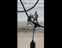 Guy films friend as he dances at the beach 