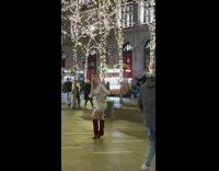 Woman in white dress and maroon boots poses at the park