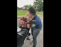 Person putting white make up on face using scooter mirror