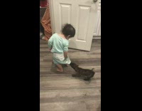 Black dog pulling on baby blue pajamas 