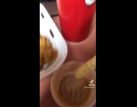 Girl dips sauce into large soda cup of sauce 