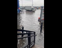 Stairs and truck pass by flooded street