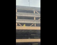 Woman yellow coat with drone at rooftop