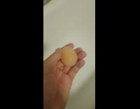 Guy holds egg without eggshell 