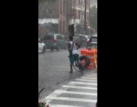 Cyclist balance TV on head rides bike rain