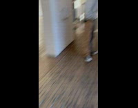 Two guys standing over a square shaped hole observing it 
