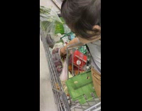 Little boy in shopping cart eats grape 