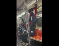 Guy in spiderman costume tries to be spiderman on train