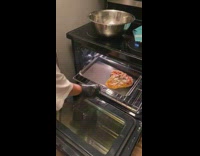 Girl takes pizza out from oven and drops it