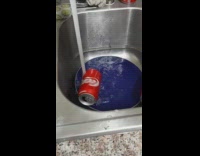 Running water spins empty red can sink