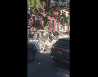 Horse drawn carriage goes down street with girls in dresses