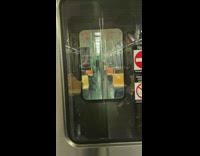 Two guys wearing green bodysuits stand subway 