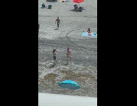 Woman in bikini with pink hair poses on the beach