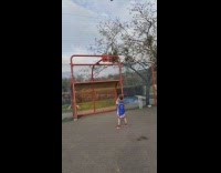 Little boy shoots basketball into orange hoop
