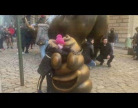 Kid poses with bronze poop statue 