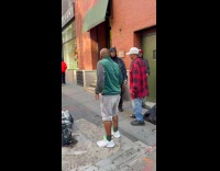 Four men sing on street with bass