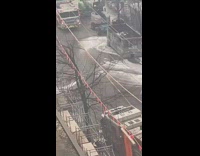 Two women poses in the street behind the fire incident