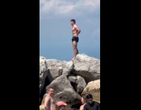 Man in black shorts beach rock photoshoot