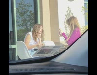 Girl poses with donut outside restaurant 