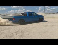 Blue truck pulls white canoe brown couch 